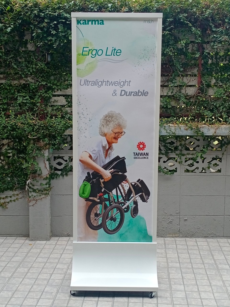 ป้ายตั้งพื้นเหล็ก สีขาว ฐานทรงสามเหลี่ยมโค้ง พร้อมล้อ ขนาด 60x160 ซม. โชว์งานพิมพ์ได้ 2 ด้าน