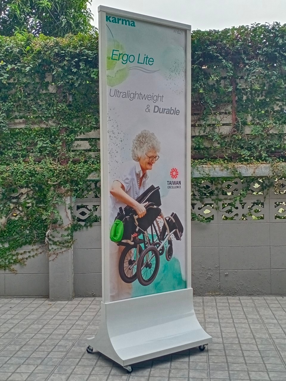 ป้ายตั้งพื้นเหล็ก สีขาว ฐานทรงสามเหลี่ยมโค้ง พร้อมล้อ ขนาด 60x160 ซม. โชว์งานพิมพ์ได้ 2 ด้าน