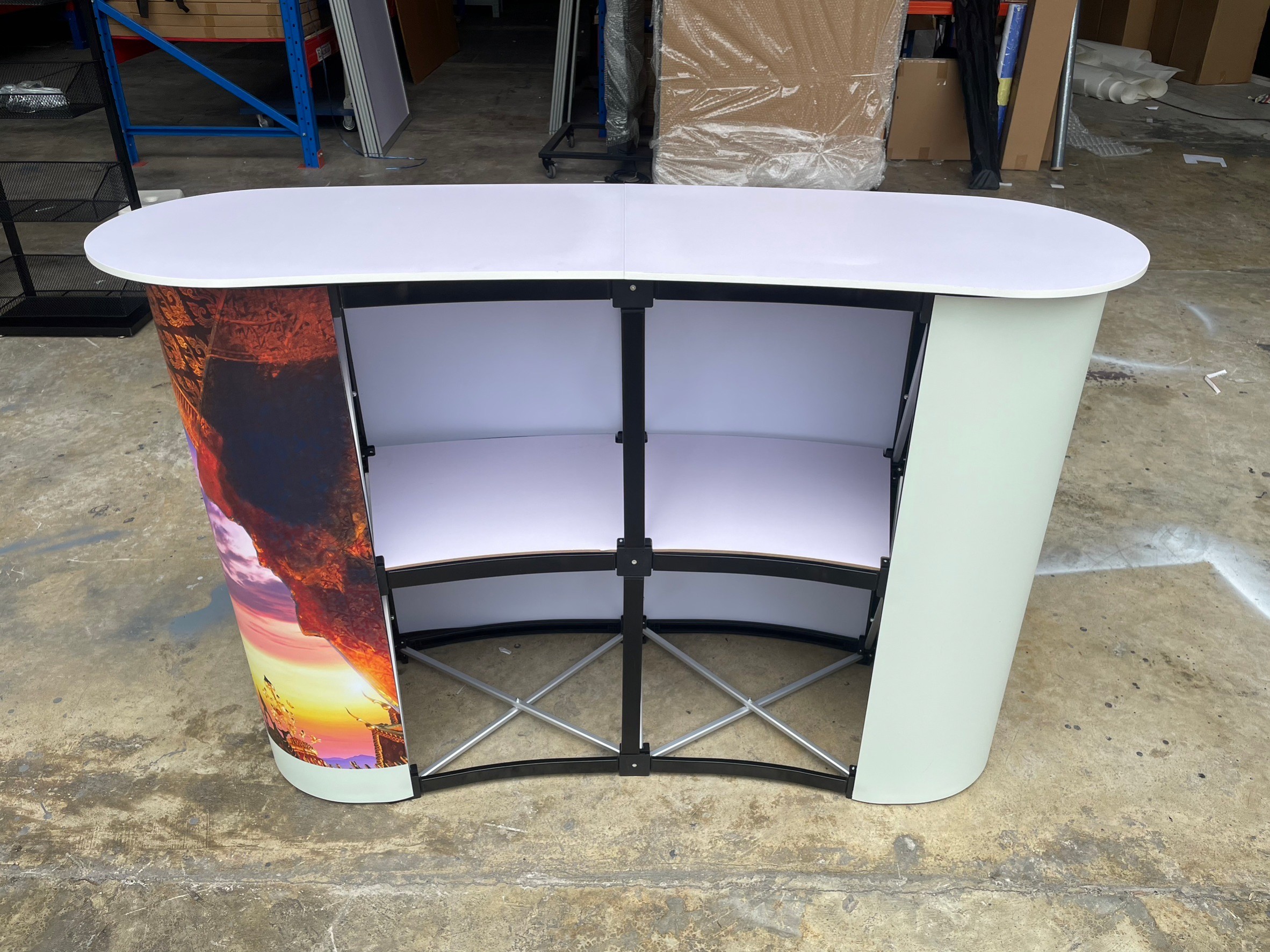 เคาน์เตอร์ออกบูธ รุ่นโค้ง TOPสีขาว มีชั้นวาง ขนาด (W)131 x (D)39 x (H) 87 cm.โครงอะลูมิเนียม พับเก็บได้ เคลื่อนย้ายสะดวก