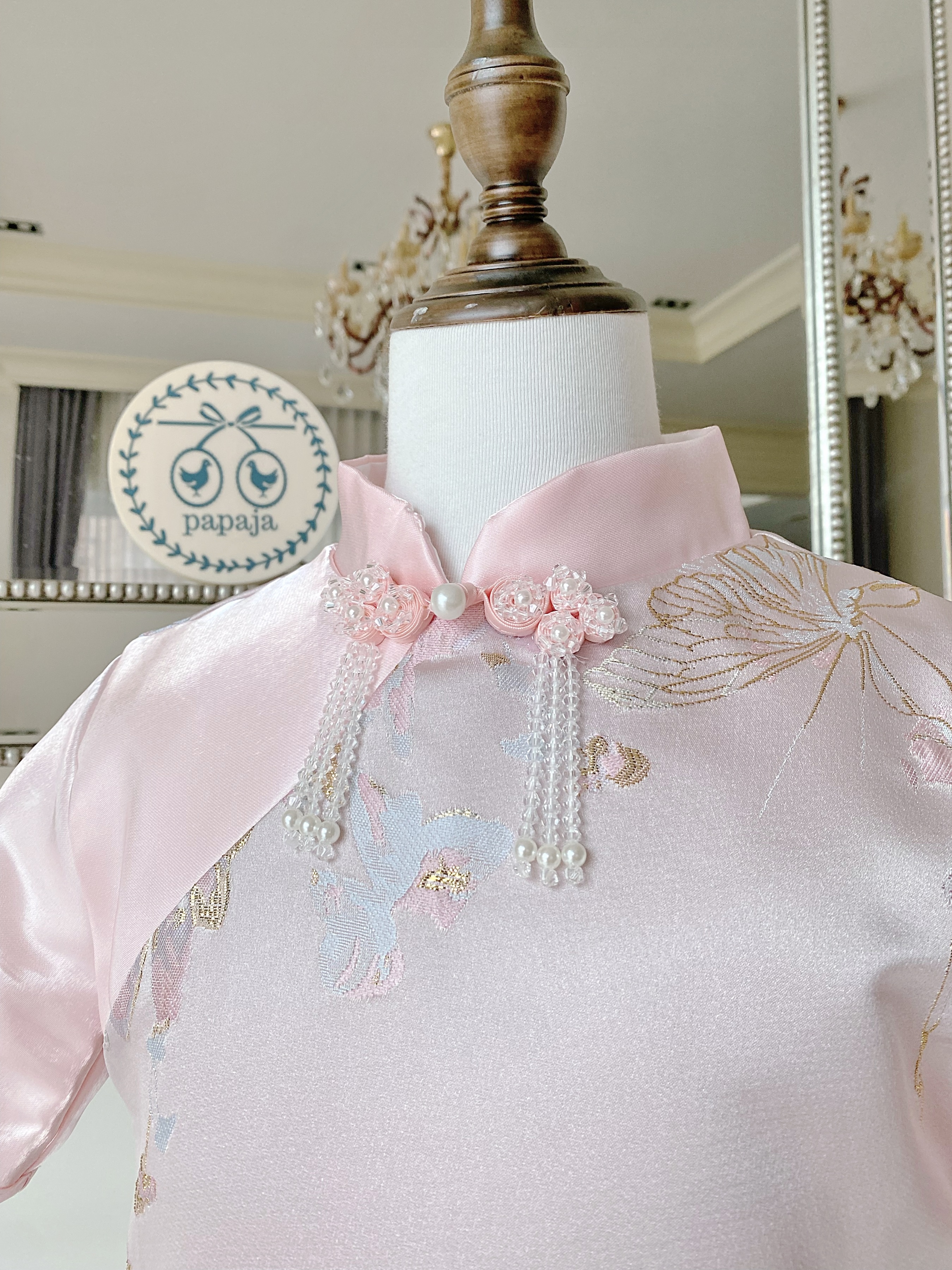 เดรสกี่เพ้าสีชมพูตุ่นแขนสั้น ผ้าแพรปักลายผีเสื้อดอกไม้สีโทนพาสเทลสวยหวานลงตัว ดีเทลกระดุมจีนประดับคริสตัลสวยมาก